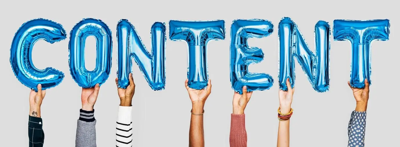 Hände, die das aus Ballons geformte Wort „Content“ zeigen.